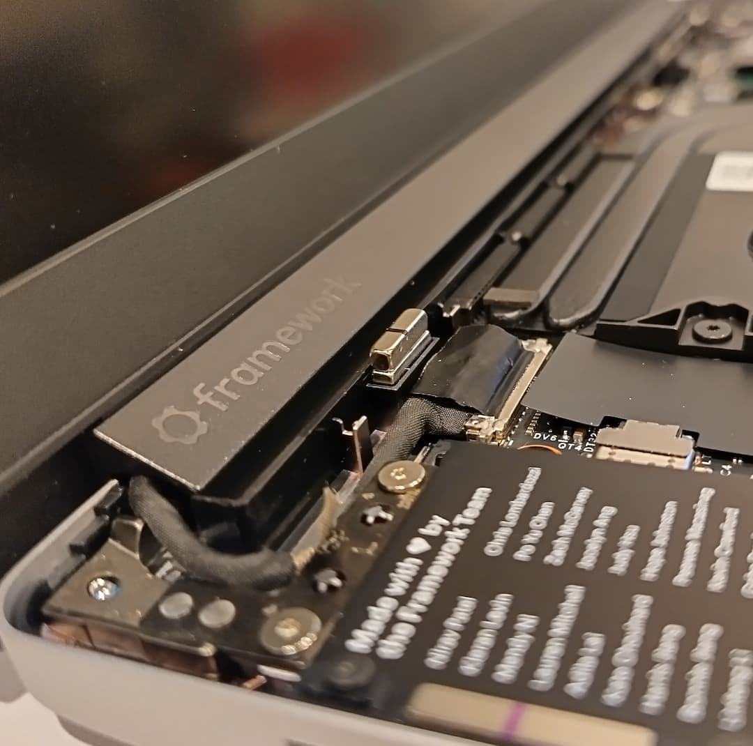 View of Framework laptop main board with keyboard removed; a small silver rectangle can be seen standing above other components